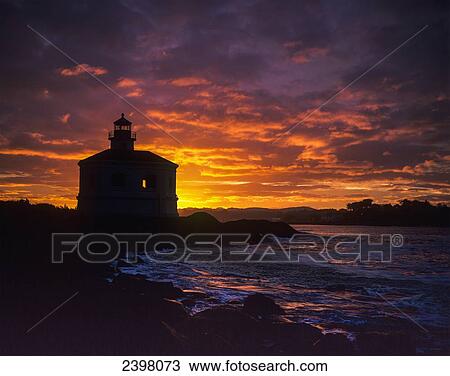 The sun rises behind the Coquille River Lighthouse; Bandon, Oregon, United States of America View Large Photo Image Stock Image - The sun rises behind the Coquille River Lighthouse; Bandon, Oregon, United States of America. Fotosearch