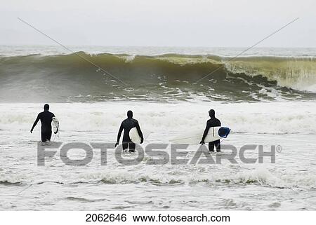 Stock Photograph - Three Surfers Head Out Into The Waves, Jordan River, Bc, Canada. Fotosearch