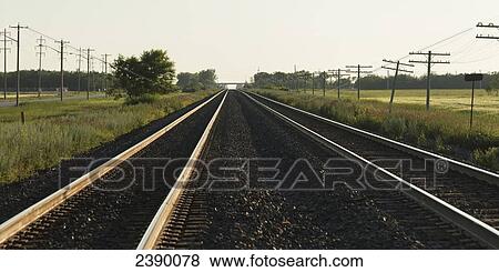 Stock Photo - Train tracks leading into the horizon on the prairies; Winnipeg, Manitoba, Canada. Fotosearch