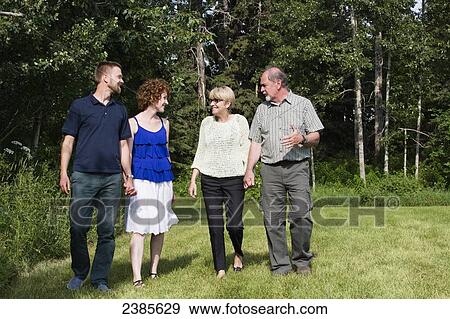 Two couples of different generations walk and talk together in a park; Stony Plain, Alberta, Canada View Large Photo Image Stock Photo - Two couples of different generations walk and talk together in a park; Stony Plain, Alberta, Canada. Fotosearch
