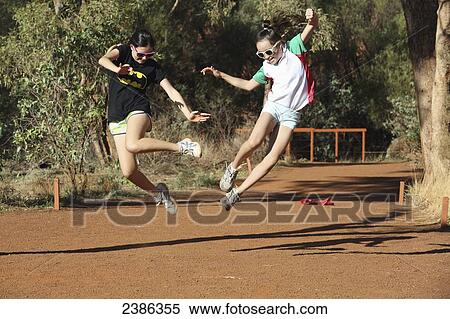 Two girls leaping in the air together; Australia View Large Photo Image Stock Photography - Two girls leaping in the air together; Australia. Fotosearch