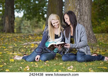 Two teenage girls reading the Bible together in a park; Edmonton, Alberta, Canada View Large Photo Image Stock Photo - Two teenage girls reading the Bible together in a park; Edmonton, Alberta, Canada. Fotosearch