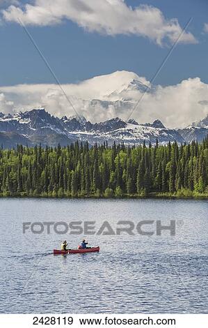 Two women and young girl in a red canoe on Byers lake with green forested shoreline and Mount McKinley peaking through the clouds, Denali State Park; Alaska, United States of America View Large Photo Image Stock Photo - Two women and young girl in a red canoe on Byers lake with green forested shoreline and Mount McKinley peaking through the clouds, Denali State Park; Alaska, United States of America. Fotosearch
