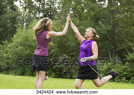 Two women golfers celebrate a great putt; Edmonton, Alberta, Canada View Large Photo Image Picture - Two women golfers celebrate a great putt; Edmonton, Alberta, Canada. Fotosearch