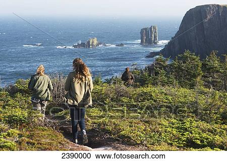 Two young women walking down a trail leading to the Atlantic ocean; Port Rexton, Newfoundland and Labrador, Canada View Large Photo Image Stock Image - Two young women walking down a trail leading to the Atlantic ocean; Port Rexton, Newfoundland and Labrador, Canada. Fotosearch