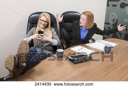 Stock Image - Unhappy boss upset at intern for texting instead of working; Edmonton, Alberta, Canada. Fotosearch - Search Stock Photos, Mural Pictures, Photographs, and Photo Clipart