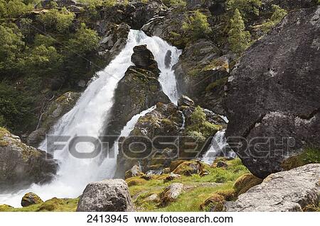 Waterfall rushing over rocks and splashing into a river; Olden, Norway View Large Photo Image Stock Photography - Waterfall rushing over rocks and splashing into a river; Olden, Norway. Fotosearch