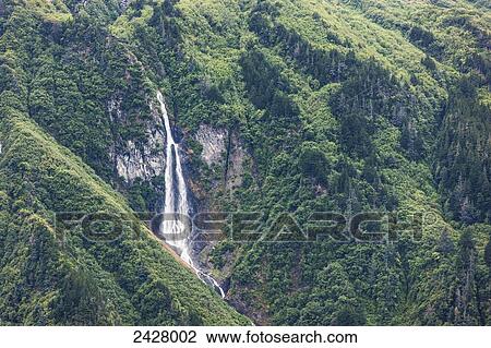 Waterfall spilling down a green forested mountain side, Prince William Sound; Whittier Alaska, United States of America View Large Photo Image Stock Image - Waterfall spilling down a green forested mountain side, Prince William Sound; Whittier Alaska, United States of America. Fotosearch