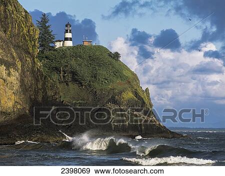 Stock Photo - Waves break at Cape Disappointment Lighthouse; Ilwaco, Washington, United States of America. Fotosearch