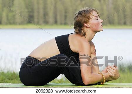 Stock Photo - Woman Exercising On Yoga Mat, Beside Grayling Lake, Riding Mountain National Park, Manitoba, Canada. Fotosearch
