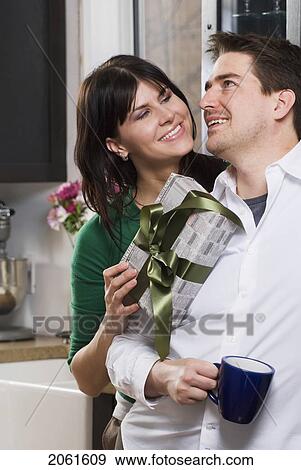 Woman Giving Man Gift, Wrapped In Newsprint With Reusable Fabric Ribbon. Wrapping Gifts In Comics, Newsprint, Or Old Maps Eliminates The Waste Of Wrapping Paper, Winnipeg, Canada View Large Photo Image Stock Photo - Woman Giving Man Gift, Wrapped In Newsprint With Reusable Fabric Ribbon. Wrapping Gifts In Comics, Newsprint, Or Old Maps Eliminates The Waste Of Wrapping Paper, Winnipeg, Canada. Fotosearch