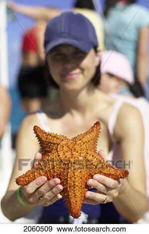 Stock Photo - Woman Holding Starfish, Camaguey, Cuba. Fotosearch
