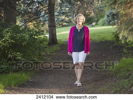 Picture - Woman walking in Hawrelak Park; Edmonton, Alberta, Canada. Fotosearch