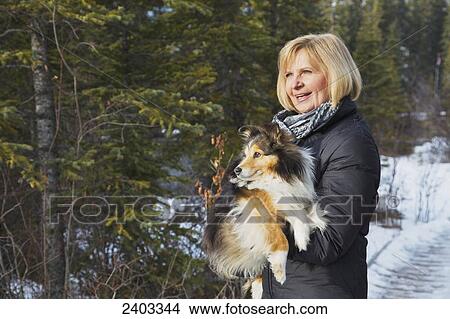 Picture - Woman walking with her dog, near Canmore; Alberta, Canada. Fotosearch