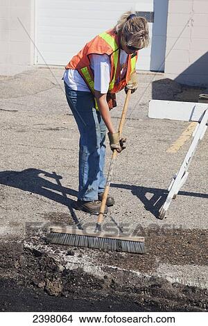 Woman working to repair pot holes in parking lot; Edmonton, Alberta, Canada View Large Photo Image Picture - Woman working to repair pot holes in parking lot; Edmonton, Alberta, Canada. Fotosearch