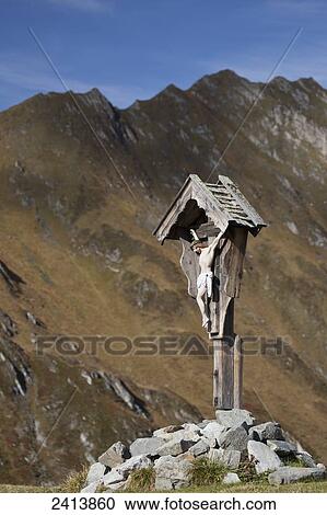 Wooden crucifix memorial on grassy slope with mountain range and blue sky in the background; Hintertux, Austria View Large Photo Image Stock Image - Wooden crucifix memorial on grassy slope with mountain range and blue sky in the background; Hintertux, Austria. Fotosearch
