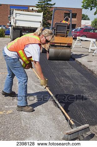 Stock Photo - Work crew working to repair pot holes in parking lot; Edmonton, Alberta, Canada. Fotosearch
