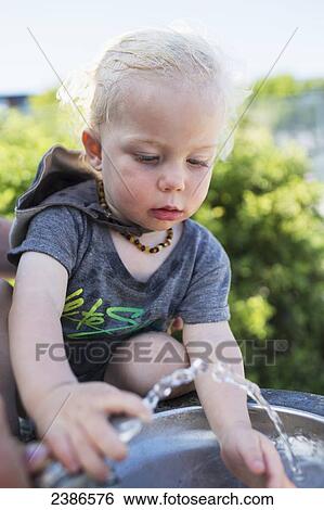 Young boy at the drinking fountain on a hot summer day; Toronto, Ontario, Canada View Large Photo Image Stock Photograph - Young boy at the drinking fountain on a hot summer day; Toronto, Ontario, Canada. Fotosearch