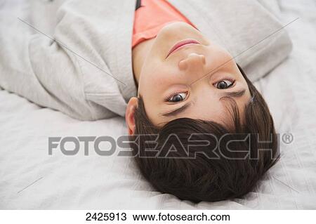 Young boy caught daydreaming laying on his bed; Langley, British Columbia, Canada View Large Photo Image Stock Image - Young boy caught daydreaming laying on his bed; Langley, British Columbia, Canada. Fotosearch