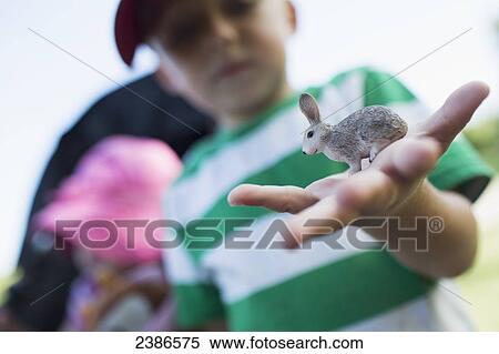 Young boy holding a toy rabbit in his outstretched hand; Toronto, Ontario, Canada View Large Photo Image Stock Photography - Young boy holding a toy rabbit in his outstretched hand; Toronto, Ontario, Canada. Fotosearch