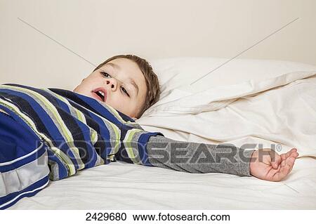 Young boy laying on a bed; Connecticut, United States of America View Large Photo Image Stock Image - Young boy laying on a bed; Connecticut, United States of America. Fotosearch