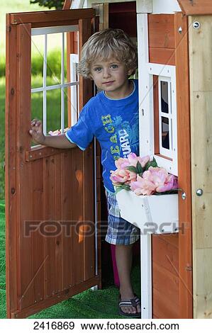 Stock Photo - Young boy playing in a playhouse; Thunder Bay, Ontario, Canada. Fotosearch