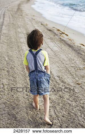 Young boy walking on the beach; Hollywood, Florida, United States of America View Large Photo Image Stock Photo - Young boy walking on the beach; Hollywood, Florida, United States of America. Fotosearch
