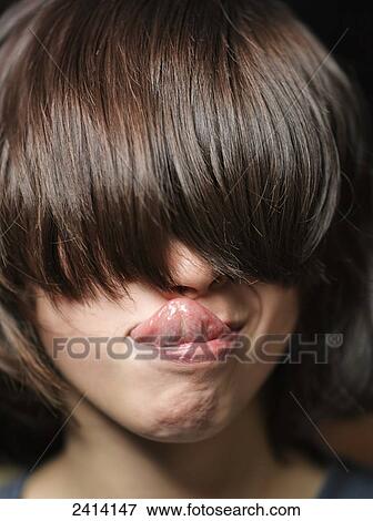 Young boy with long brunette hair covering his eyes and sticking out his tongue View Large Photo Image Stock Photo - Young boy with long brunette hair covering his eyes and sticking out his tongue. Fotosearch