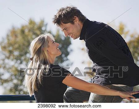 Stock Image - Young couple in love looking into each other's eyes; Edmonton, Alberta, Canada. Fotosearch