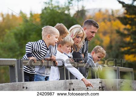 Young family on a bridge in a park in autumn; Edmonton, Alberta, Canada View Large Photo Image Stock Photo - Young family on a bridge in a park in autumn; Edmonton, Alberta, Canada. Fotosearch