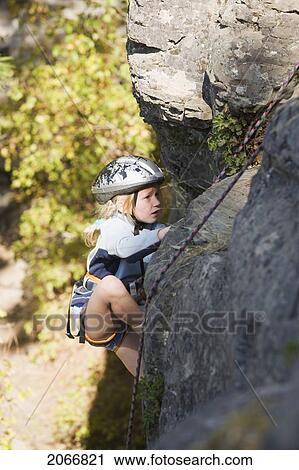 Stock Image - Young Girl (Age 7) Climbing On Granite Cliff At Stone Hills Near Rexford, Montana, Usa. Fotosearch