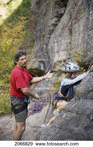 Stock Photo - Young Girl (Age 7) Preparing To Climb While Father Belays At Stone Hills Near Rexford, Montana, Usa. Fotosearch