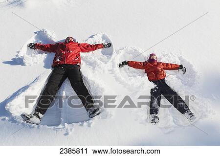 Young girl and her mother making snow angels in wintertime; Talkeetna, Alaska, United States of America View Large Photo Image Stock Image - Young girl and her mother making snow angels in wintertime; Talkeetna, Alaska, United States of America. Fotosearch