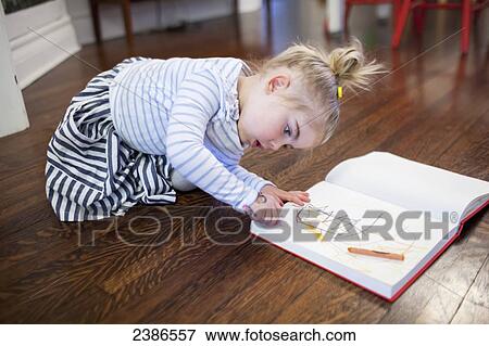 Young girl doodling in her sketchbook with crayons on the dining room floor; Toronto, Ontario, Canada View Large Photo Image Stock Photo - Young girl doodling in her sketchbook with crayons on the dining room floor; Toronto, Ontario, Canada. Fotosearch