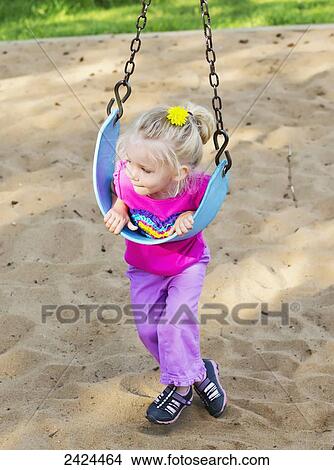 Young girl on a swing in the park; St. Albert, Alberta, Canada View Large Photo Image Picture - Young girl on a swing in the park; St. Albert, Alberta, Canada. Fotosearch