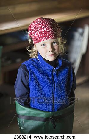 Picture - Young girl wearing a red bandana standing in a dry bag in a cabin, Byers lake campground, Denali State Park; Alaska, United States of America. Fotosearch