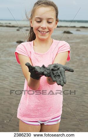 Young girl wearing pink on a shore showing her muddy hands; Charlevoix, Quebec, Canada View Large Photo Image Stock Image - Young girl wearing pink on a shore showing her muddy hands; Charlevoix, Quebec, Canada. Fotosearch