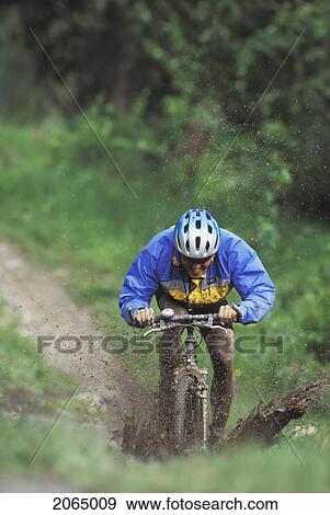 Young Man Mountain Biking Through Mud Near Fernie, Bc, Canada View Large Photo Image Stock Photo - Young Man Mountain Biking Through Mud Near Fernie, Bc, Canada. Fotosearch