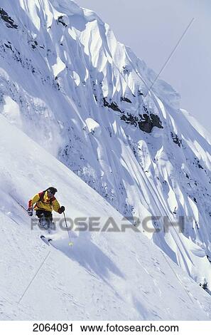 Stock Image - Young Man Skiing Fresh Powder On Steep Slope At Island Lake Resort, Fernie, British Columbia, Canada.. Fotosearch