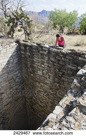 Young mexican woman looking down into a deep well or mine shaft; Guanajuato, Mexico View Large Photo Image Stock Photo - Young mexican woman looking down into a deep well or mine shaft; Guanajuato, Mexico. Fotosearch