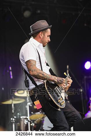 Picture - Young musician playing guitar at a concert; Edmonton, Alberta, Canada. Fotosearch
