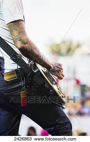 Stock Image - Young musician playing guitar at a concert; Edmonton, Alberta, Canada. Fotosearch