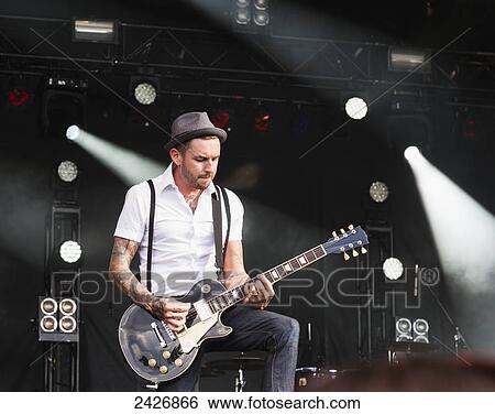 Young musician playing guitar at a concert; Edmonton, Alberta, Canada View Large Photo Image Stock Photograph - Young musician playing guitar at a concert; Edmonton, Alberta, Canada. Fotosearch