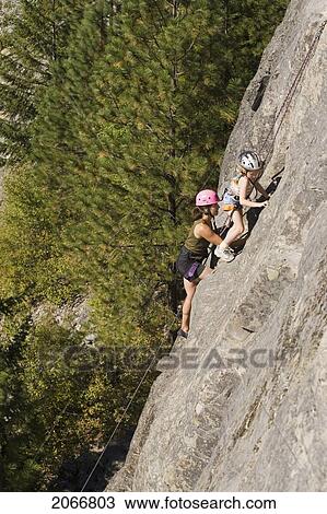 Young Woman Climbing With Daughter (Age 7) Up Granite Cliff At Stone Hills Near Rexford, Montana, Usa View Large Photo Image Stock Image - Young Woman Climbing With Daughter (Age 7) Up Granite Cliff At Stone Hills Near Rexford, Montana, Usa. Fotosearch