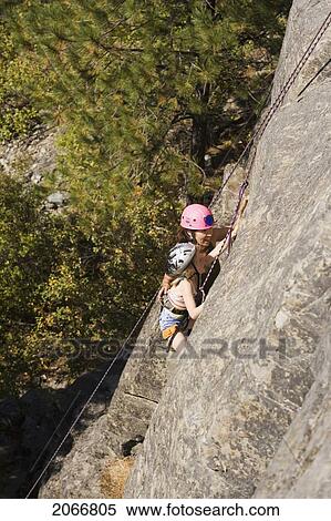 Young Woman Climbing With Daughter (Age 7) Up Granite Cliff At Stone Hills Near Rexford, Montana, Usa View Large Photo Image Stock Photography - Young Woman Climbing With Daughter (Age 7) Up Granite Cliff At Stone Hills Near Rexford, Montana, Usa. Fotosearch
