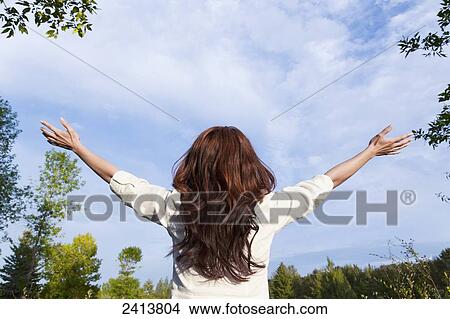 Picture - Young woman raising her hands in worship; Edmonton, Alberta, Canada. Fotosearch