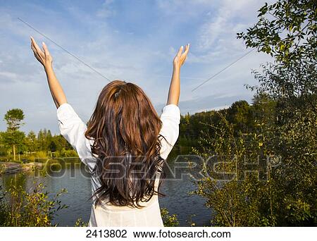 Young woman raising her hands in worship in a park; Edmonton, Alberta, Canada View Large Photo Image Stock Image - Young woman raising her hands in worship in a park; Edmonton, Alberta, Canada. Fotosearch