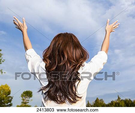 Stock Image - Young woman raising her hands in worship; Edmonton, Alberta, Canada. Fotosearch