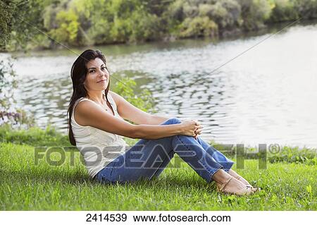 Young woman relaxing on the shore of a lake; Edmonton, Alberta, Canada View Large Photo Image Stock Photo - Young woman relaxing on the shore of a lake; Edmonton, Alberta, Canada. Fotosearch