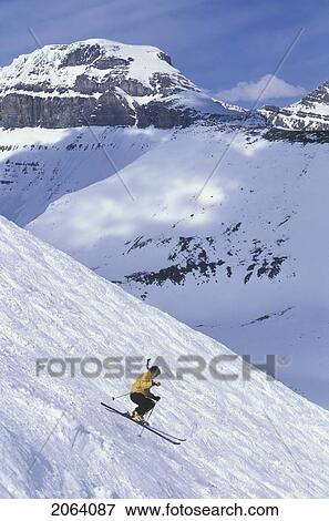Stock Photo - Young Woman Skiing In The Bumps At Lake Louise Resort, Alberta, Canada.. Fotosearch
